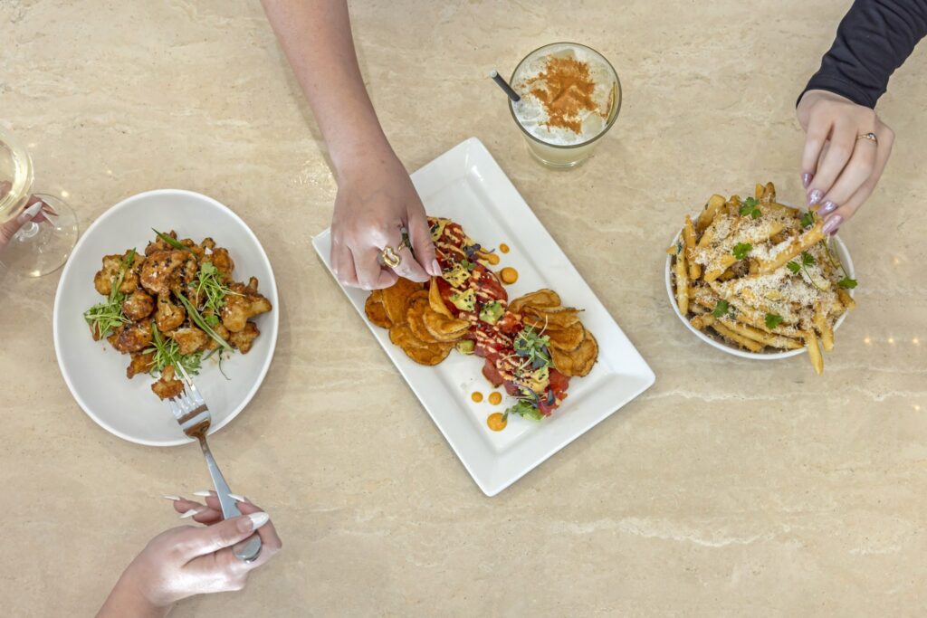 Image of three plates shot from above with hands reaching in