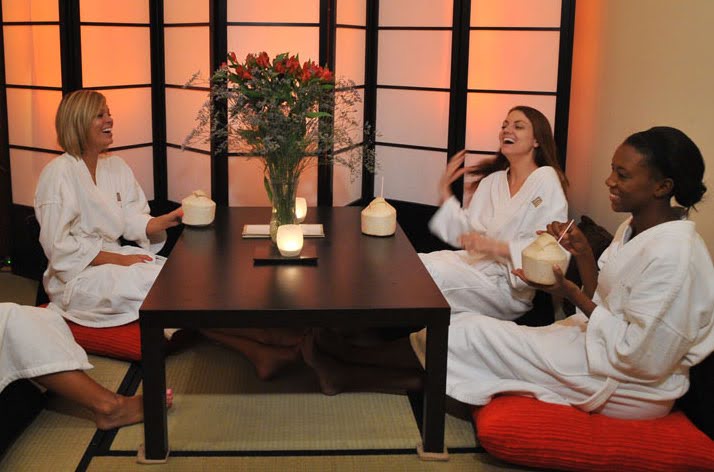 Women in white robes around a table at the spa