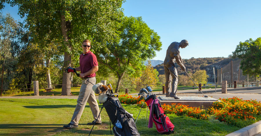 Man next to his golf clubs on the course.