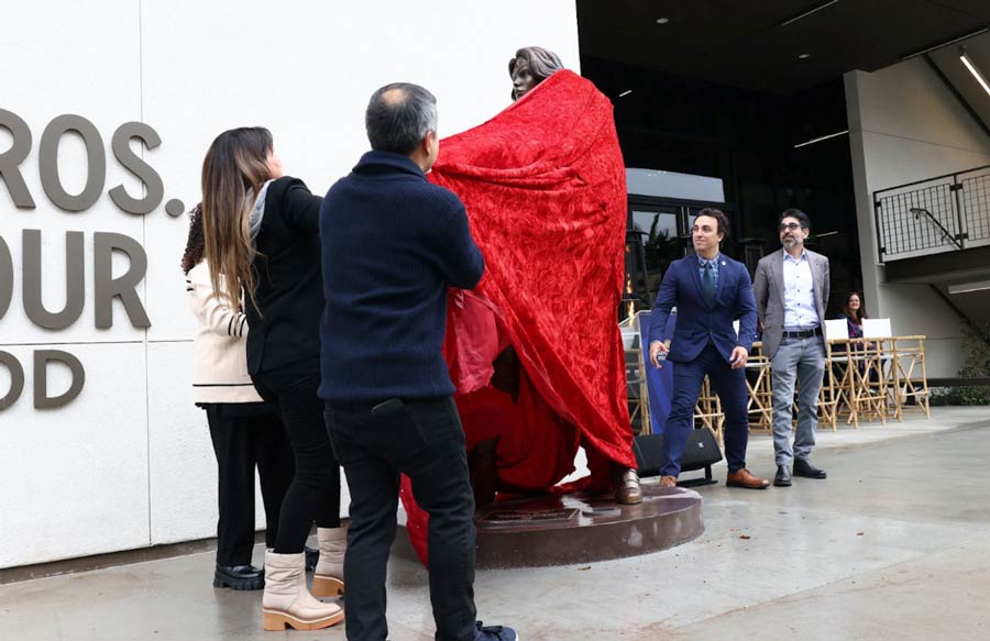 People crowd around the wonder woman statue as it's unveiled